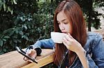 Happy Young Woman Drinking Coffee Outdoors And Using Smartphone Stock Photo