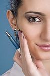 Happy Young Woman With A Pen In Hand Over Blue Background Stock Photo