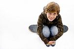 High Angle View Of Boy Sitting On Skateboard Stock Photo