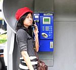 Hispanic Woman Talking In A Public Phone Stock Photo