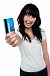 Joyous Brunette Showing Her Credit Card To You Stock Photo