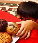 Kid Taking Cake From Table Stock Photo