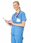 Lady Doctor Standing With Clipboard Stock Photo