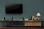 Led Tv On Dark Green Wall With Wooden Media Furniture Stock Photo