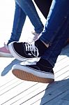 Legs Of Young Girl In Jeans And Sneakers Stock Photo