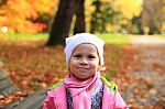 Lifestyle Portrait Of Little Smiling Girl In Autumn Park Stock Photo