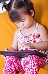 Little Asian Girl Using Digital Tablet, Child Finger Point At Co Stock Photo