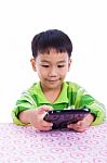 Little Asian (thai) Boy Using Digital Tablet At Desk Stock Photo