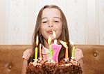 Little Girl Blowing Out The Candles Stock Photo