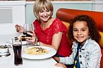 Little Girl Enjoying Dinner With Her Mom Stock Photo