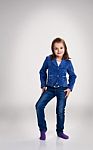 Little Girl In Blue Jeans And Jacket Posing In The Studio Stock Photo