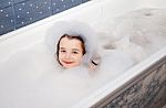 Little Girl Lying In A Bath With Soap Suds Stock Photo