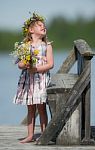 Little Girl With Flowers Looking Up Stock Photo