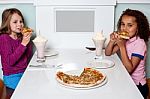 Little Girls Enjoying Pizza In A Restaurant Stock Photo