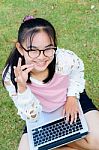 Lovely Girl With A Laptop On The Grass Stock Photo