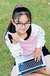 Lovely Girl With A Laptop On The Grass Stock Photo