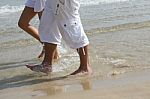 Male And Female Walking At Beach Stock Photo