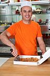 Male Chef Slicing Pizza Into Pieces Stock Photo