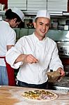 Male Chefs Actively Working In Kitchen Stock Photo