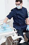 Male Dentist With Tools At Dental Office Stock Photo