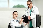 Male Doctor Handing Over Files Stock Photo