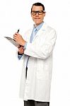 Male Doctor Writing Medical Report Stock Photo