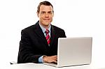 Male Executive At Work Desk Operating Laptop Stock Photo