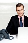 Male Executive Wearing Headsets And Smiling Stock Photo