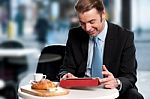 Male Manager Browsing Internet On Tablet Device Stock Photo