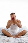 Male Sipping Coffee Sitting On Bed Stock Photo