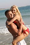 Man Carrying Woman At Beach Stock Photo