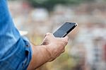 Man Hand Holding Mobile Phone In The City Stock Photo