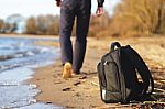 Man Left His Backpack And Walking On The Beach Stock Photo