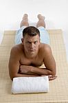 Man Lying On Mat For Spa Treatment Stock Photo