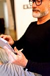 Man Middle-aged Browsing Through His Tablet Stock Photo