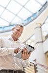 Man With Tablet Computer In Modern Business Building Stock Photo