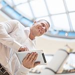 Man With Tablet Computer In Modern Business Building Stock Photo