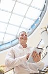 Man With Tablet Computer In Modern Business Building Stock Photo