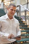 Man With Tablet Computer In Modern Business Building Stock Photo