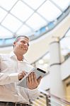 Man With Tablet Computer In Modern Business Building Stock Photo