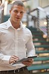 Man With Tablet Computer In Modern Business Building Stock Photo