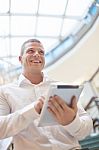 Man With Tablet Computer In Modern Business Building Stock Photo