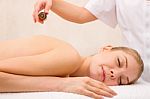 Masseuse Pouring Massage Oil Woman's Back Stock Photo