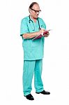 Mature Medical Practitioner Writing Case History Of A Patient Stock Photo