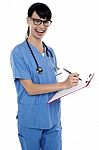 Medical Nurse Jotting Down Notes On Writing Pad Stock Photo