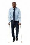 Middle Aged Man Walking With Two Crutches Stock Photo