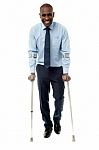 Middle Aged Man Walking With Two Crutches Stock Photo