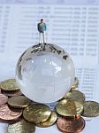 Miniature Businessman Stand On Globe Of Glass, Euro Coins And Bo Stock Photo