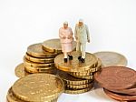 Miniature Senior Couple Stand On Pile Of Euro Coins. Retirement Stock Photo