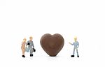 Miniature Worker Making Heart Shaped Chocolate On White Background Stock Photo